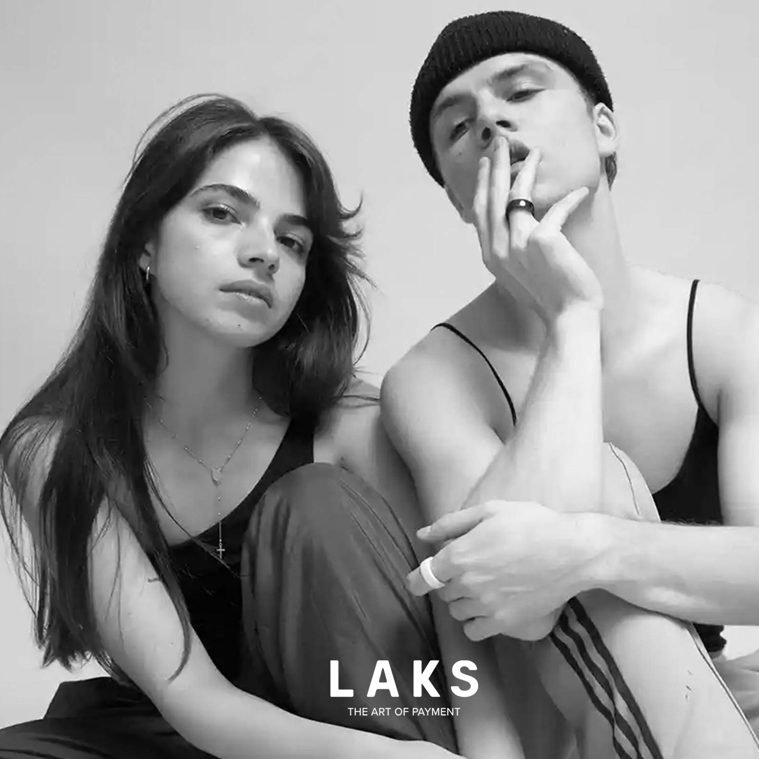 paar in schwarz weiß, er hat Hand mit Bezahlring am Mund und Schriftzug Laks unten mittig